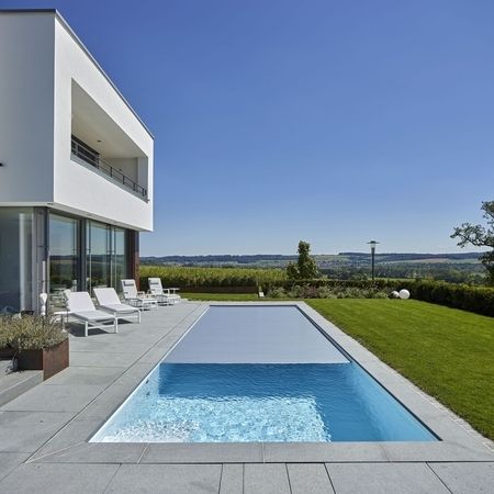 Modernes Ambiente mit einem Pool und Rolladenabdekung