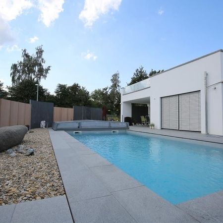 Moderner Pool vor einem weißen Haus
