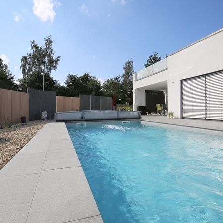 Moderner Pool vor einem weißen Haus