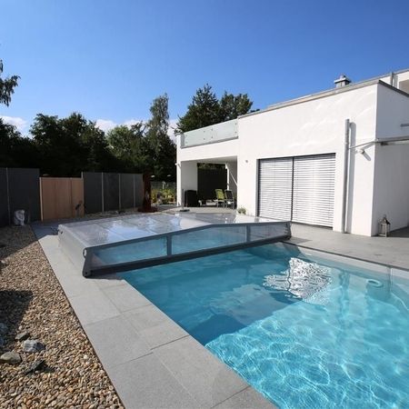 Moderner Pool vor einem weißen Haus