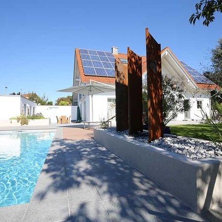 Großer Pool vor einem modernem Haus