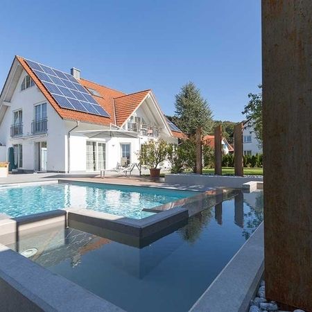 Großer Pool vor einem modernem Haus