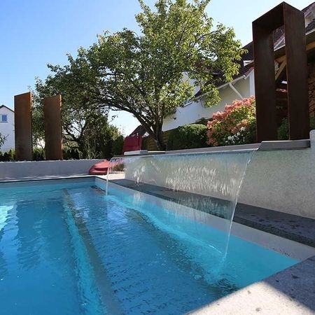 Großer Pool vor einem modernem Haus