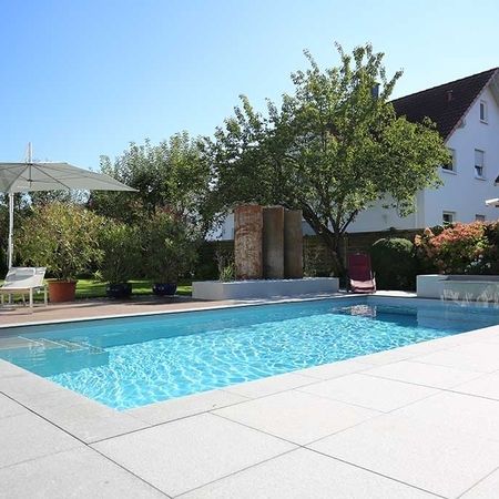 Großer Pool vor einem modernem Haus