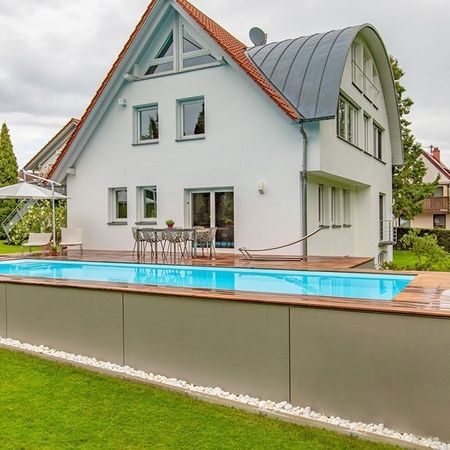 Großer Pool vor einem Haus mit einer Holzverkleidung