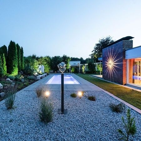 Moderner Pool vor einem Haus bei Abend