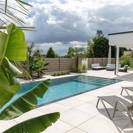 Moderner Pool vor einem weißen Haus