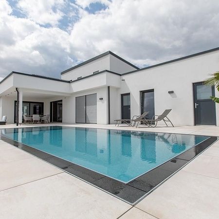 Moderner Pool vor einem weißen Haus