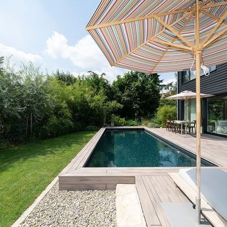 Moderner Pool vor einem Haus mit einem Sonnenschirm