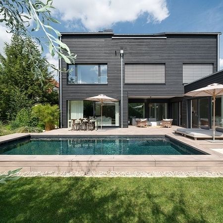 Moderner Pool vor einem Haus mit einem Sonnenschirm