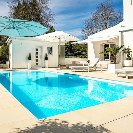 Moderner Pool vor einem weißen Haus