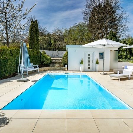 Moderner Pool vor einem weißen Haus