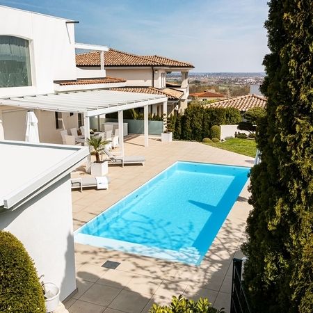 Moderner Pool vor einem weißen Haus von oben