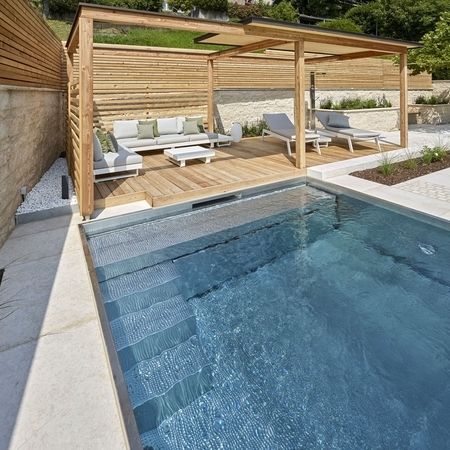 Ein Pool aus Edelstahlbecken und Holzelementen