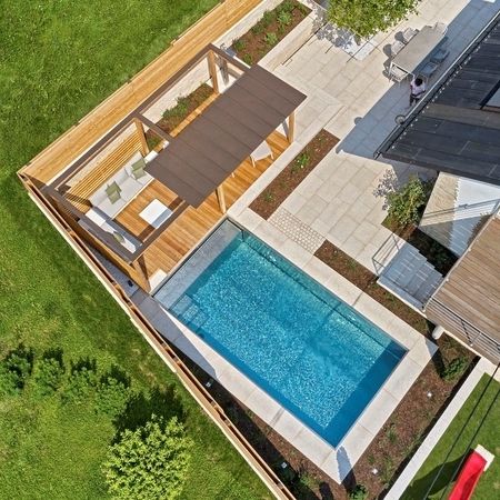 Ein Pool aus Edelstahlbecken und Holzelementen von oben
