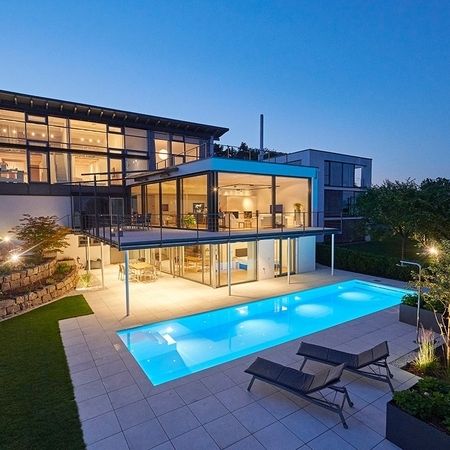 Ein modernes Haus mit einem Pool bei Nacht