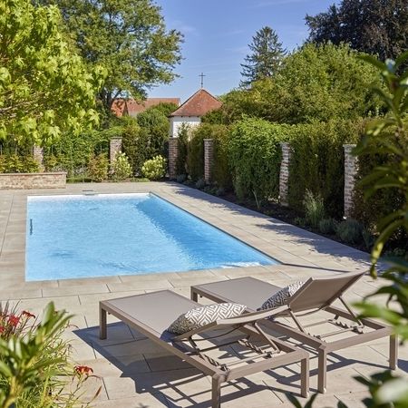 Ein Haus und ein Pool mit Liegen
