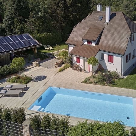 Ein Haus und ein Pool mit Liegen