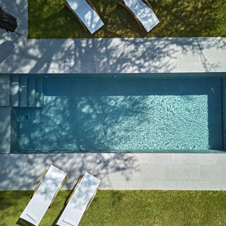 Luxuriöser Pool mit Liegestühlen von oben