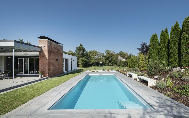 Großer Pool vor einem Haus im Garten